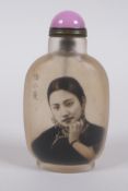 A Chinese reverse decorated glass snuff bottle decorated with a female figure, character inscription