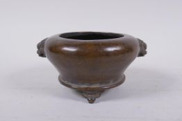 A Chinese bronze censer on tripod supports with two fo dog mask handles, impressed mark to base,