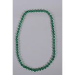 A green jade bead necklace, 68cm long