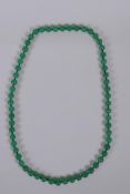 A green jade bead necklace, 68cm long