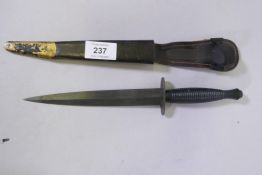 A third pattern Commando dagger, marked William Rodgers, Sheffield, in a leather sheath with brass