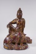 A Sino Tibetan gilt and coppered bronze figure of Buddha seated on a temple lion, 32cm high