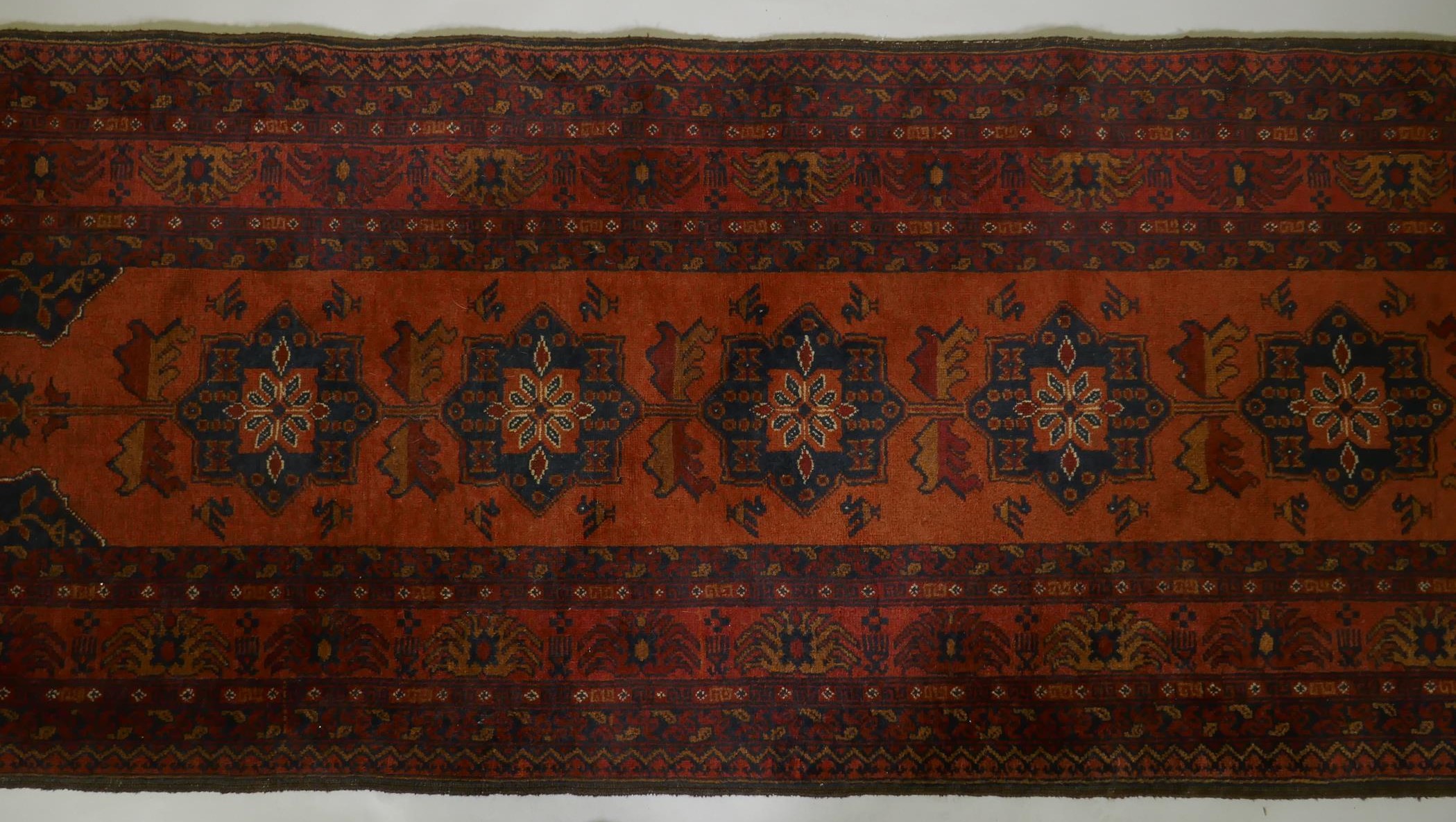 An antique oriental red ground wool runner decorated with geometric floral medallions and birds, - Image 3 of 5