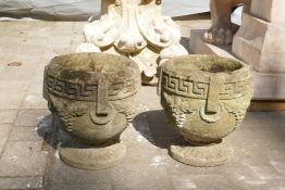 A pair of weathered concrete garden urns, 26cm high