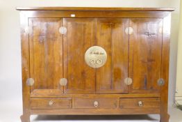 A Chinese hardwood cabinet with brass mounts and folding doors, raised on shaped supports, 186 x