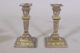 A pair of Victorian Adam style silver candlesticks, London 1894, maker's mark rubbed, 16cm high