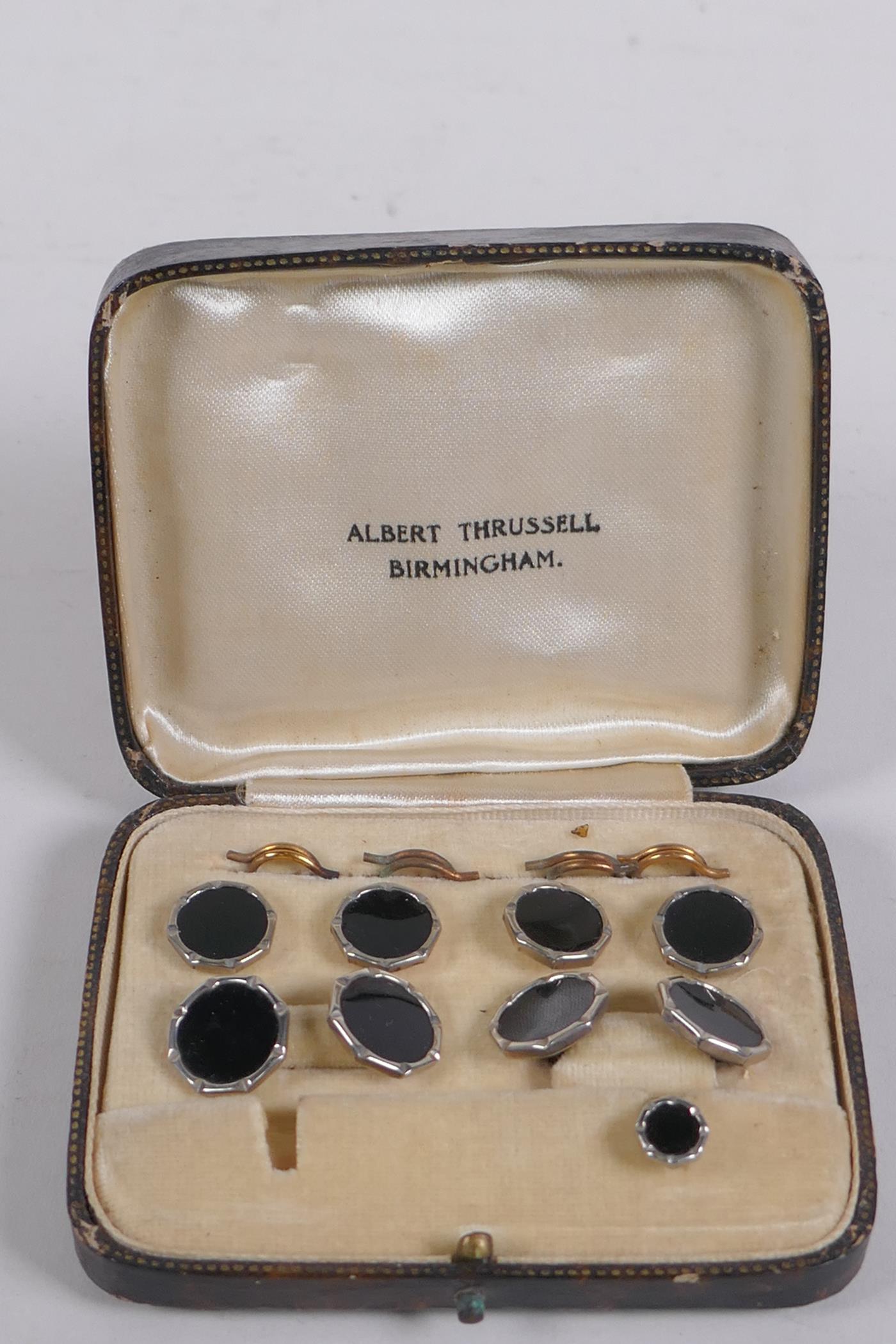 A cased set of black enamel and white metal cufflinks and studs, 1 stud missing
