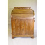 A late C19th/early C20th walnut tobacconist's shop cabinet, the roll top opening to reveal drawers