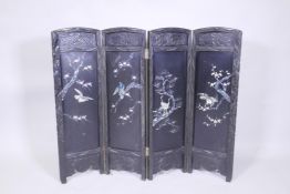 An antique Japanese four fold black lacquer screen with inlaid mother of pearl and abalone