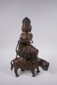 A Sino Tibetan filled gilt bronze Buddha, seated on the back of a mythical creature, 32cm high