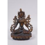 A Sino Tibetan gilt bronzed metal female deity seated in meditation, 20cm high