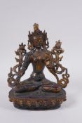 A Sino Tibetan gilt bronzed metal female deity seated in meditation, 20cm high