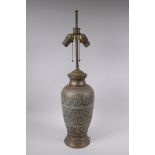 An Islamic brass vase with chased script decoration, converted to a table lamp, 67cm high