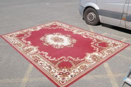 A large oriental red ground carpet with a cream floral medallion and borders, 240 x 330cm