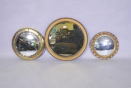 A vintage convex wall mirror with brass frame, 48cm diameter, another with pierced frame and a
