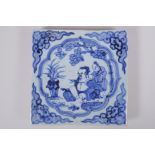 A Chinese blue and white porcelain temple tile, decorated with a sage and attendant, 20 x 20cm
