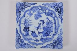 A Chinese blue and white porcelain temple tile, decorated with a sage and attendant, 20 x 20cm