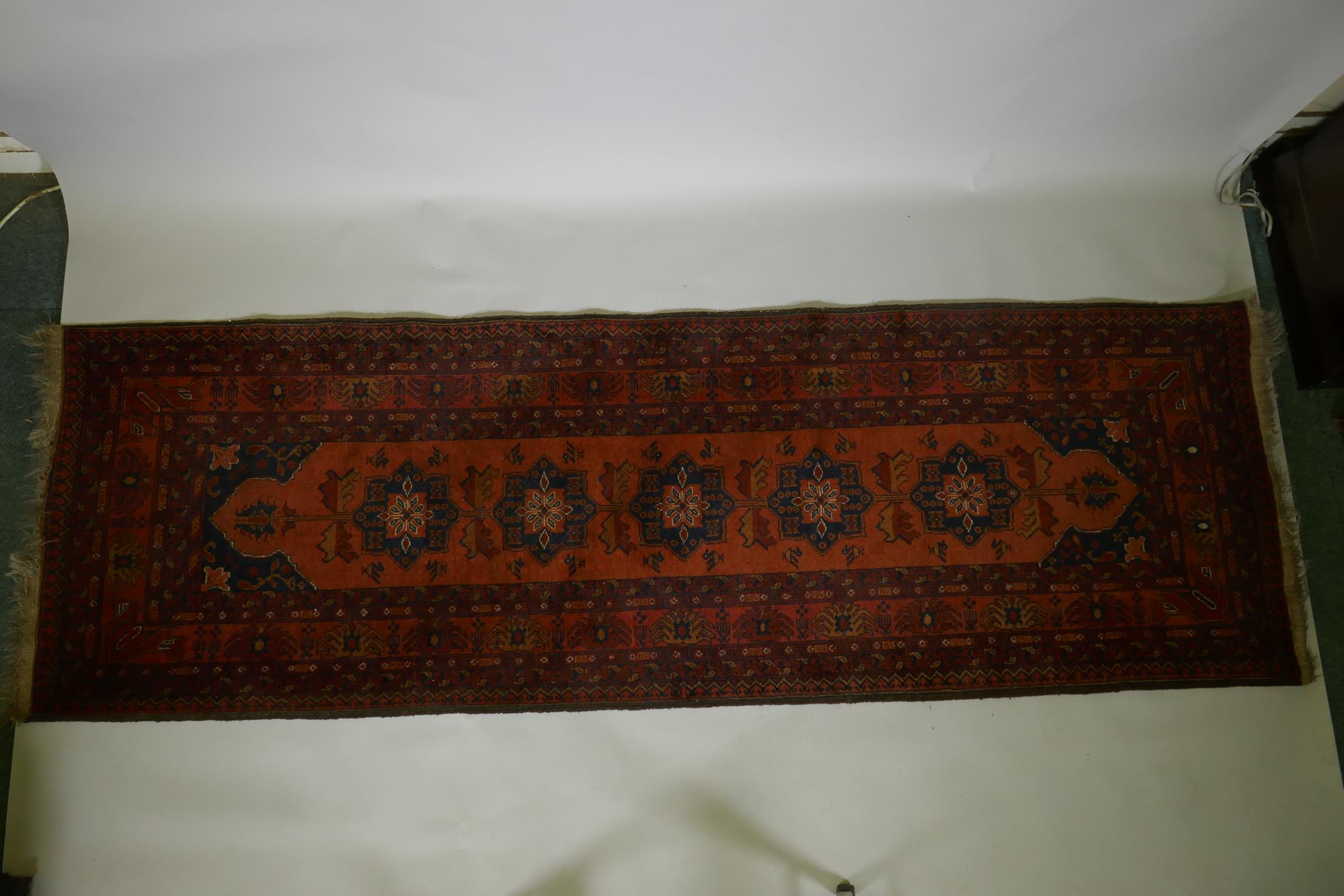 An antique oriental red ground wool runner decorated with geometric floral medallions and birds, - Image 2 of 5