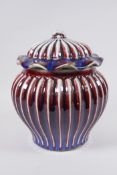 A Chinese flambe glazed porcelain ribbed ginger jar and cover, the cover with a frilled rim and loop