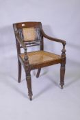 A C19th Anglo Indian style/Zanzibar hardwood elbow chair, with caned seat and back, reeded arms,