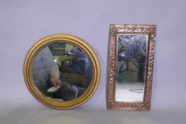 An antique Arts & Crafts copper mirror with repousse decoration, and a circular gilt wall mirror,