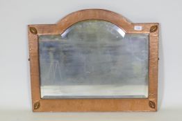 An Arts & Crafts hammered copper framed wall mirror with bevelled glass, in the manner of Liberty of