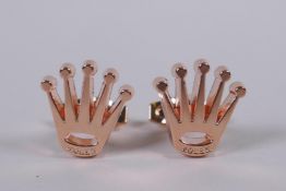 A pair of rose coloured metal Rolex style cufflinks