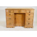 A C19th pine nine drawer kneehole desk with central cupboard raised on a shaped plinth base, 110 x