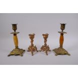 A pair of ormolu rococo style candlesticks, and a pair of gilt bronze and alabaster candlesticks,