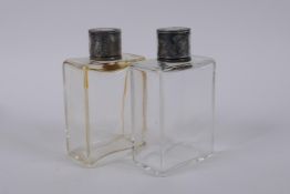 A pair of hallmarked silver topped scent bottles, London, 1938, 11cm high