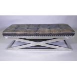 A buttoned leather bench raised on chromed metal supports, 150 x 55 x 45cm