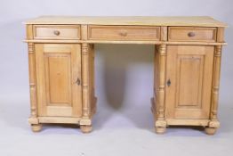 A C19th continental pine kneehole desk, with three drawers over two cupboards fitted with shelves,