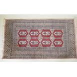 A hand woven wool Bokhara rug, medallion design on a pink ground, 94 x 150cm