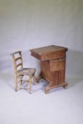 A Victorian pitch pine desk, with pen tray and inkwell, lift up top and side flap and door to