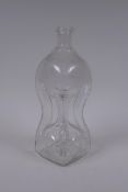 An antique glass bottle of pinched waist form and etched decoration, 28cm high