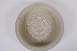 A Chinese celadon ground porcelain dish, the bowl with raised decoration of the animals of the