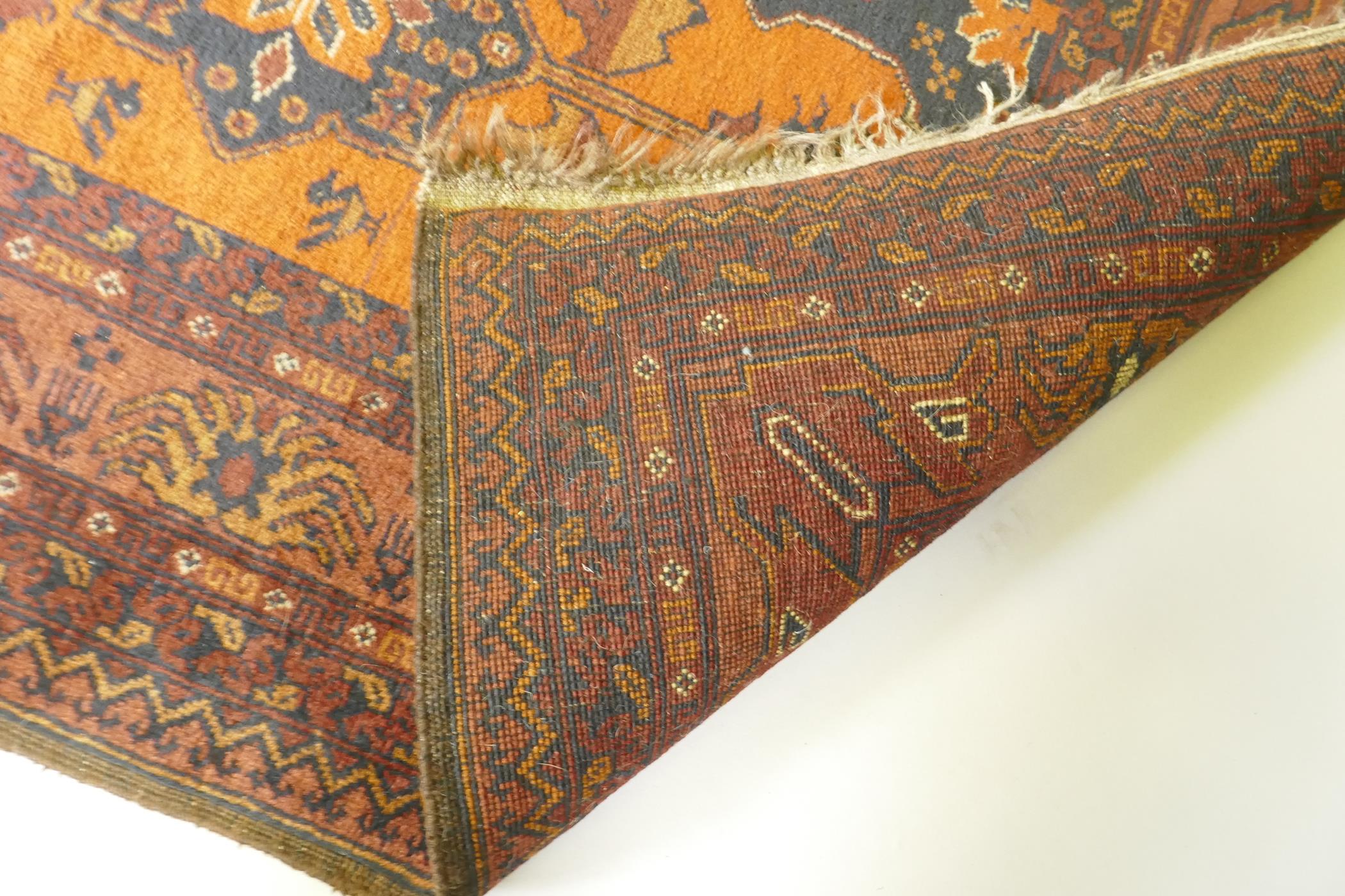 An antique oriental red ground wool runner decorated with geometric floral medallions and birds, - Image 5 of 5