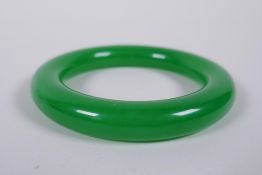 A Chinese apple jade bangle, 8cm diameter