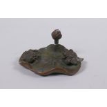 An oriental bronze incense stick holder in the form of a goldfish on a lily pad, 6cm diameter