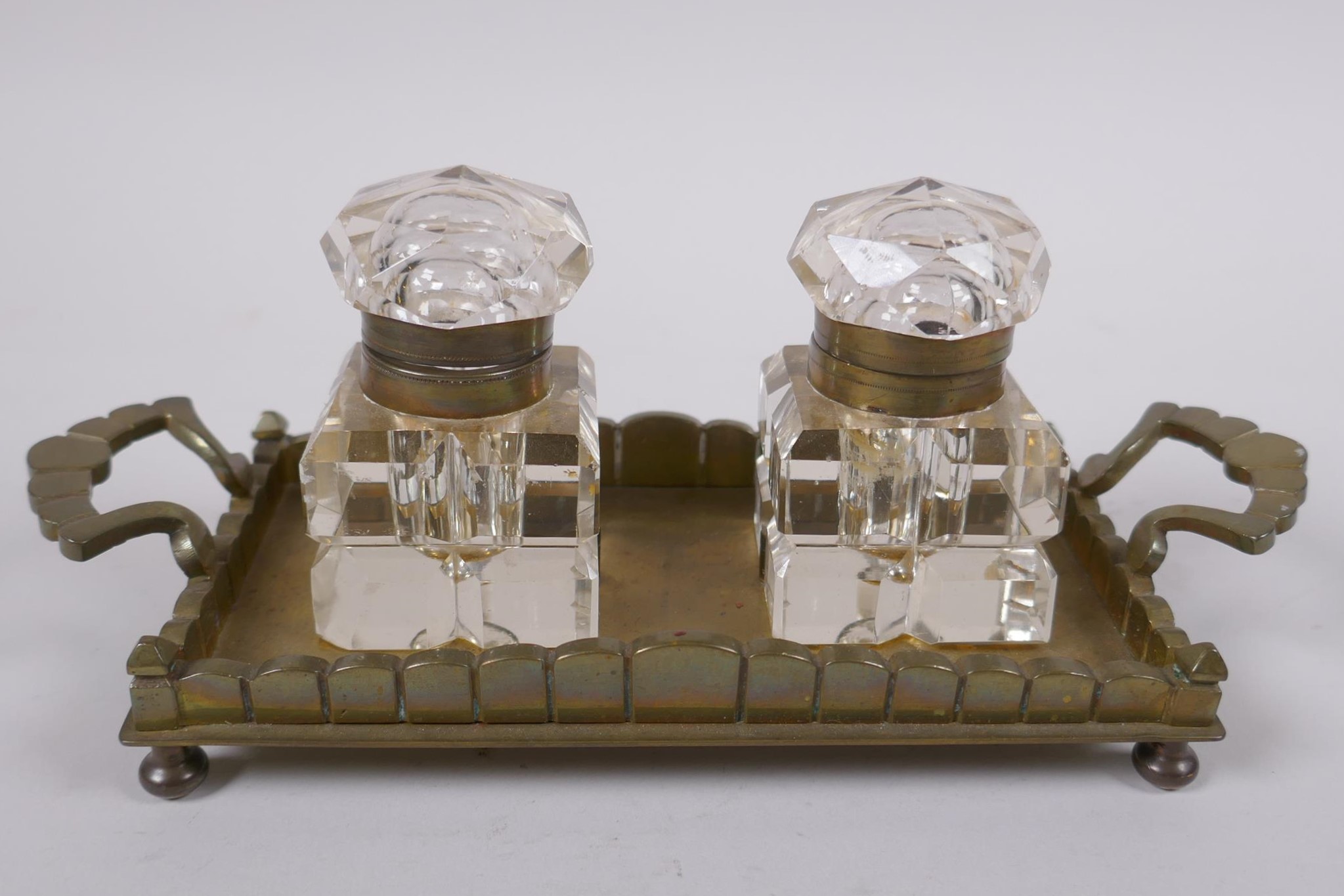 An antique brass and glass twin inkwell desk stand, 21 x 9cm