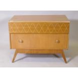 A mid century oak two drawer chest raised on splay supports, bears label, Trimline, by Tudor Rose,
