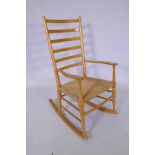 A beech wood ladder back rocking chair with rush seat