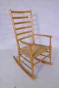 A beech wood ladder back rocking chair with rush seat