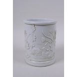 A Chinese white ground porcelain brush pot with raised decoration of water fowl on a lotus pond,