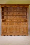 A pine dresser, the upper section with delft rack over four drawers, open sides, the base with
