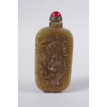A Chinese celadon hardstone snuff bottle with temple lion and landscape decoration, 7cm high