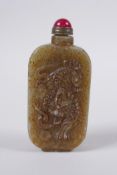 A Chinese celadon hardstone snuff bottle with temple lion and landscape decoration, 7cm high