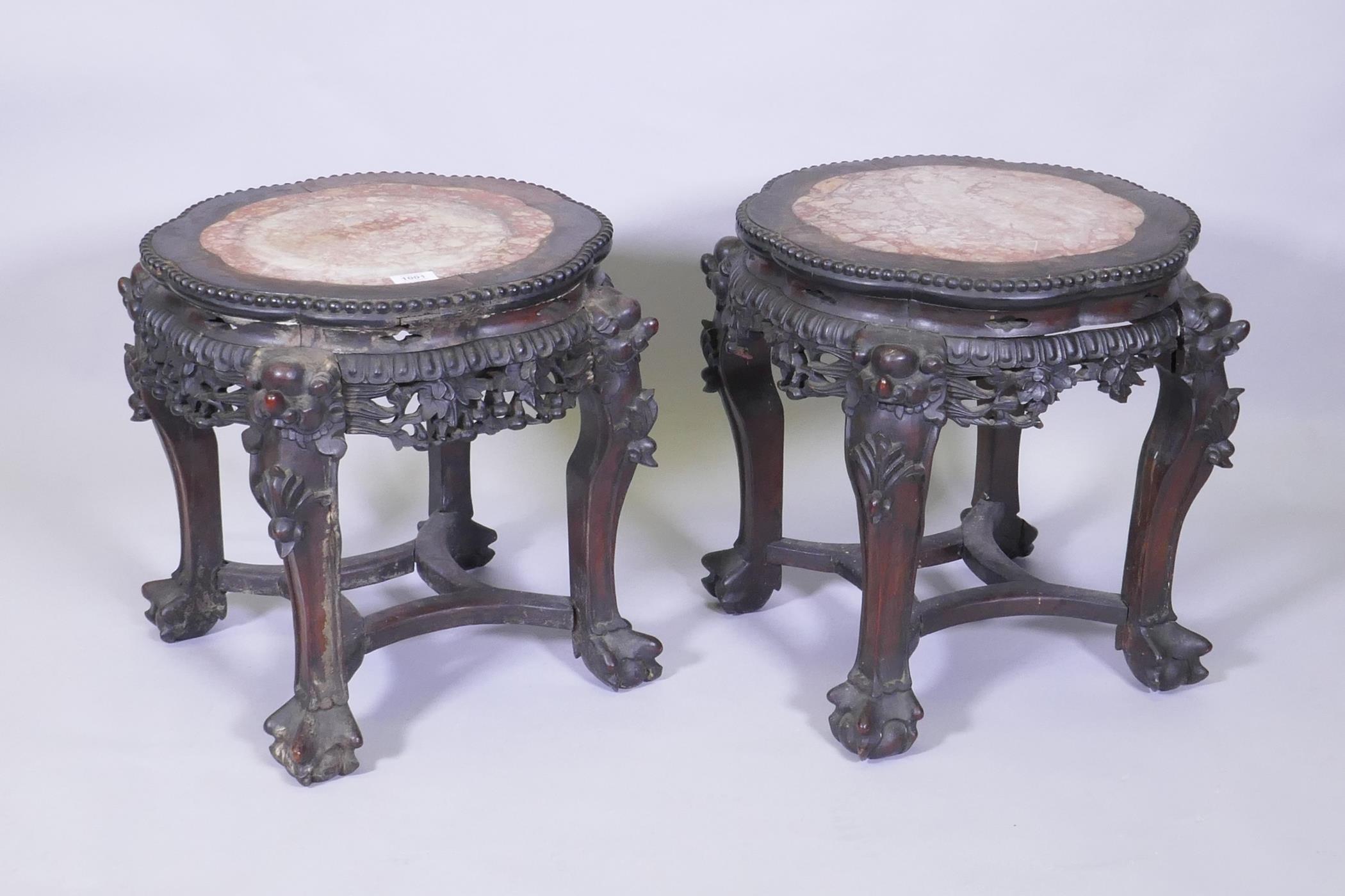 A pair of C19th Chinese hardwood tables/stands, with inset rouge marble tops, carved and pierced