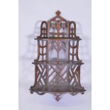 A mahogany Gothic style open fretwork hanging corner shelf, with pierced back and sides and three