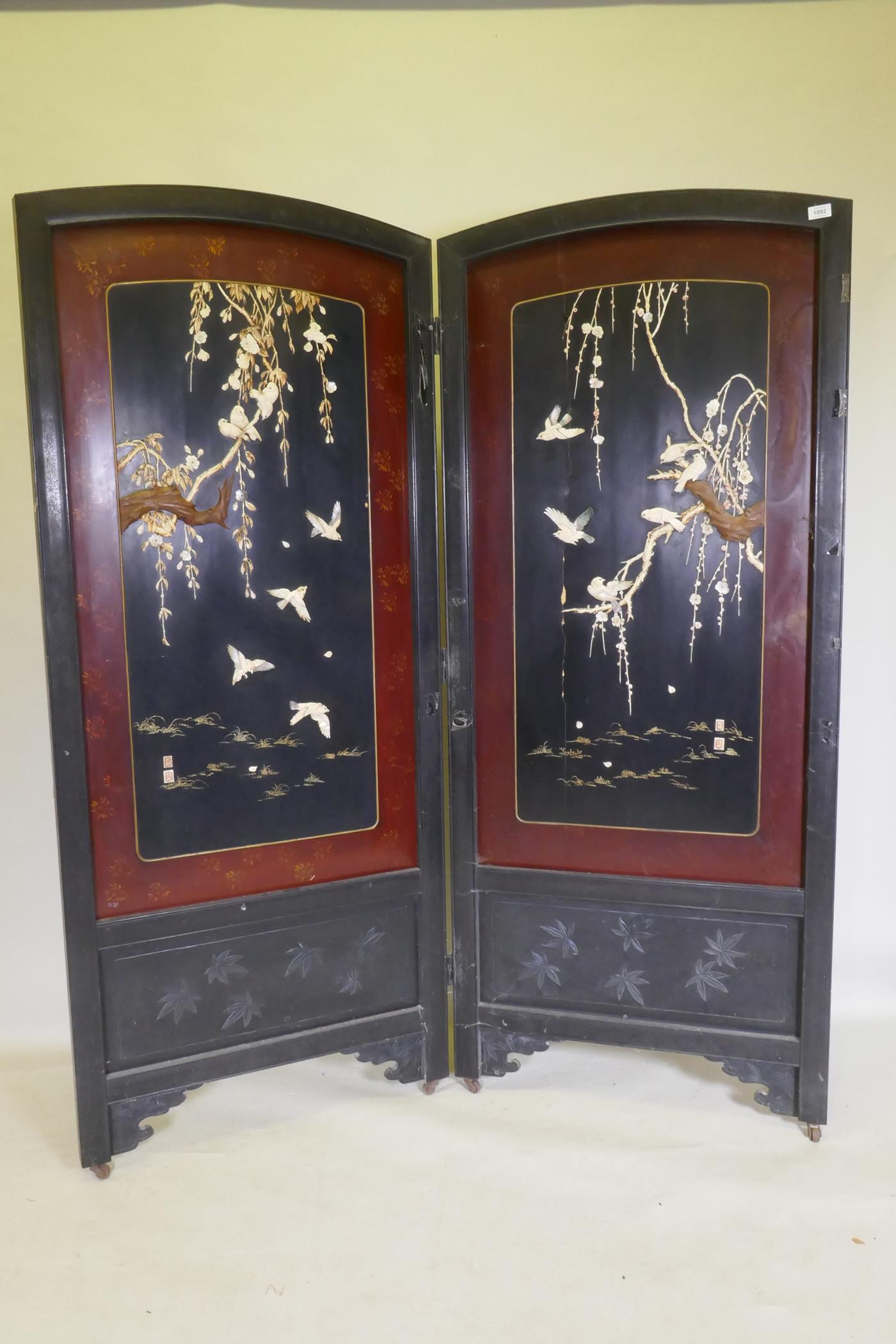 A Meiji period two fold lacquer screen, with raised decoration of birds and blossom in bone,